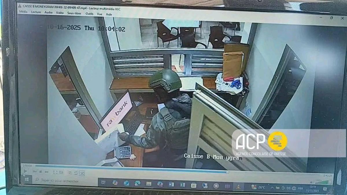 Capture d’écran d’une vidéosurveillance montrant un militaire s’emparant de l'argent dans la caisse de la Rawbank le 16 octobre 2025<br />ACP